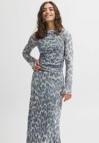 Grå leopardprint kjole med lange ærmer, lavet af et let, tekstureret stof. Har samlede detaljer i taljen og en flydende silhuet.