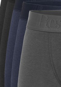 Boxer-briefs pour hommes disponibles en différentes couleurs : noir, bleu marine foncé, bleu marine, gris foncé. Tissu doux avec une ceinture texturée arborant un logo.