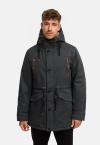 Donkergrijze parka met een capuchon met trekkoord, meerdere zakken en bruine accenten. Voorzien van een knoop- en ritssluiting aan de voorkant, met doorgestikte textuur.