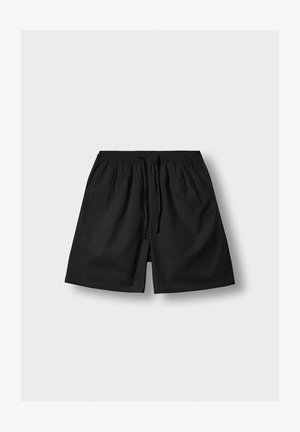Schwarze Shorts mit elastischem Bund und Kordelzug, locker geschnitten und aus dezent strukturiertem Stoff, auf hellem Hintergrund.