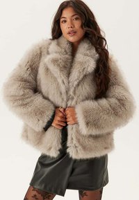 Faux furjacka i ljusgrått, med bred krage, lös passform och långa ärmar. Strukturerad yta med ett mjukt, mysigt utseende.