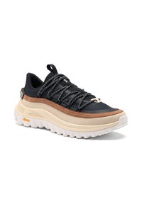 Schwarzer und brauner Sneaker mit niedrigem Schaft, dicker weißer Sohle, gemusterten schwarzen Schnürsenkeln und robustem Vibram-Außensohle für den Outdoor-Einsatz.