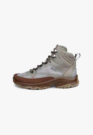 Svetlosivé a hnedé turistické topánky s Gore-Tex materiálom, polstrovanou oporou členka, robustnou podrážkou a šnúrkami s kovovými očkami na vonkajšie použitie.