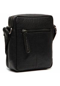 Sac bandoulière en cuir noir de forme rectangulaire. Présente une poche zippée à l'avant et une surface texturée. Sangle ajustable attachée.