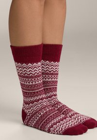 Borvörös térdzokni fehér cikk-cakk és mintás díszítéssel. Bordázott felső rész és egyszínű orr rész. Texturált kötött anyagból készült.