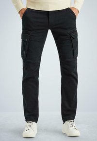 Schwarze Cargo-Hosen mit vorderen und seitlichen Taschen, aus robustem Stoff; Slim-Fit-Design; kombiniert mit weißen Sneakern auf einem hellen Hintergrund.
