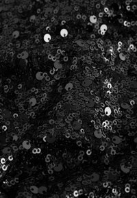 Schwarzer Paillettenstoff mit strukturierter Oberfläche, versehen mit kreisförmigen Pailletten in verschiedenen Größen, die ein reflektierendes, glänzendes Aussehen erzeugen.