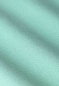 Tissu turquoise clair avec une texture lisse et un léger éclat, présentant une surface uniforme et un léger motif visuel dû à la réflexion de la lumière.