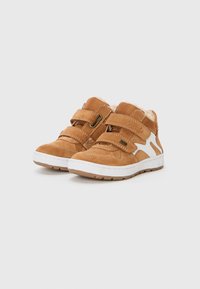 Bruine suède hoge schoenen met witte accenten, voorzien van twee klittenbandsluitingen, zachte voering en gestructureerde rubberen zolen.