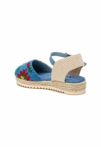 Sandalia espadrille azul con bordado floral, correa de tobillo a cuadros, interior suave y suela de plataforma de yute. Acentos de tela texturizada.