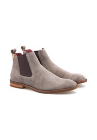 Stivali Chelsea grigi in suede con pannelli elastici scuri, linguette per l'uscita e suole in gomma marrone. Caratterizzati da una texture liscia e una punta arrotondata.