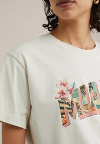 Light cream cotton t-shirt with a colorful "Miami" print featuring tropical flowers, palm trees, and retro cars. Short sleeves and round neck.
