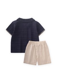 Camicetta a maniche corte a quadri blu navy con colletto e pantaloni corti a righe beige. Tessuto morbido, vita elastica, design casual adatto per il clima caldo.