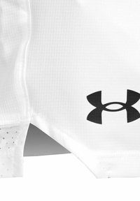 Camiseta deportiva blanca con un logo de Under Armour en negro. El material presenta un patrón texturizado; el diseño incluye un dobladillo curvado y acentos en contraste.