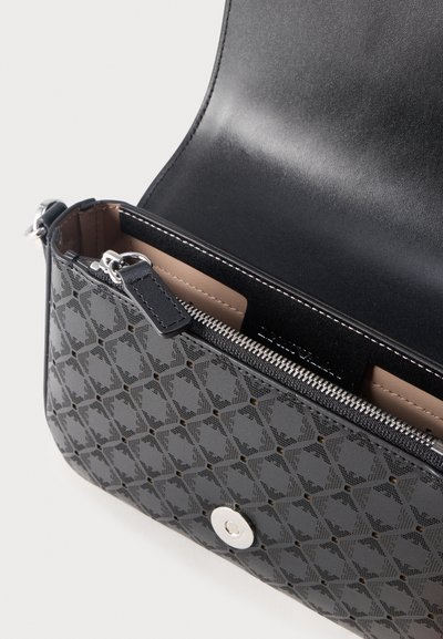 Μαύρη δερμάτινη τσάντα χειρός με σχεδιασμένο εξωτερικό, ανοιχτό καπάκι που αποκαλύπτει εσωτερικό διαμέρισμα με φερμουάρ και λεία ραμμένη επένδυση με μαγνητικό κλείσιμο.