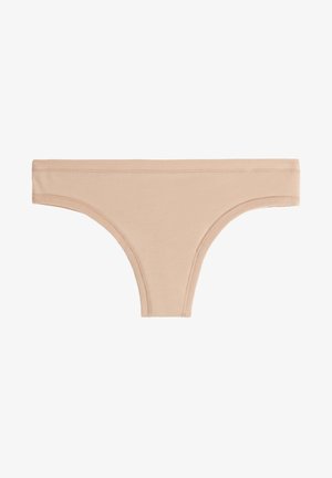 String en coton nude avec une texture douce, taille étroite et bords sans couture pour le confort. Coupe classique avec une absence d'éléments visibles.