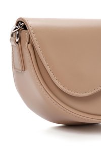 Beige leren handtas met een ronde vorm, een gebogen klep als sluiting en contrasterende stiksels. Beschikt over zilverkleurige hardware en een gladde textuur.