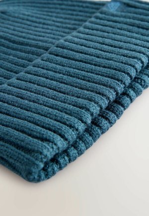 Tissu côtelé teal mettant en avant une texture douce, avec des rangées de rayures surélevées et un bord replié, offrant une apparence chaleureuse.