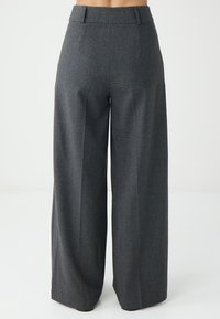 Wijdvallende broek in gestructureerde donkergrijze stof, met een hoge tailleband, subtiele stikdetails en geen zichtbare zakken.