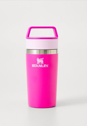 Taza de viaje Stanley aislada de color rosa brillante con tapa rosa claro, banda plateada y asa sobre fondo blanco.