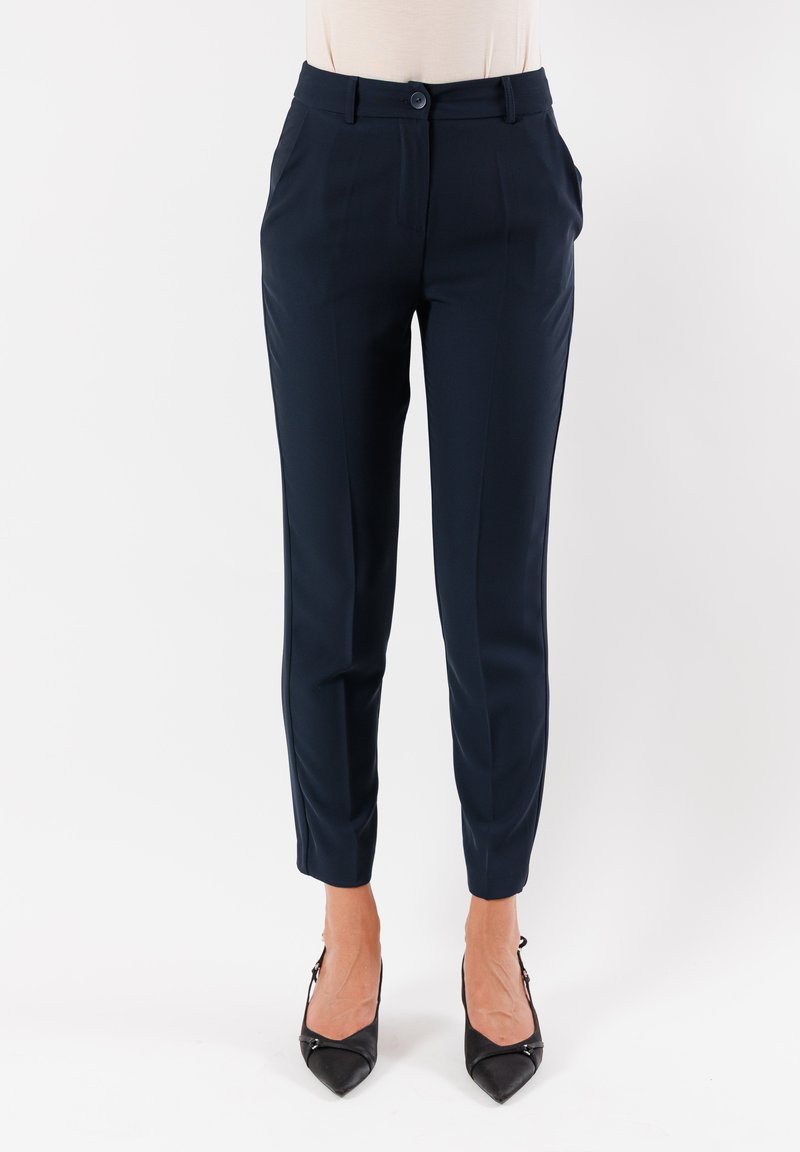 Pantaloni tailored blu navy realizzati in un tessuto morbido. Presentano una chiusura frontale con bottone, passanti per cintura e tasche laterali, con gambe affusolate.
