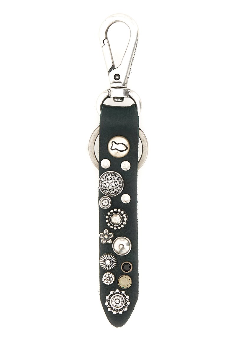 Portachiavi in pelle verde con accessori in argento, caratterizzato da vari chiodi metallici decorativi e dettagli, tra cui un simbolo di pesce e disegni floreali.