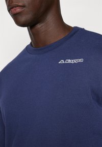 Navy blauwe sweatshirt van katoen met een ronde hals. Voorzien van een klein wit Kappa-logo op de borst, met een gladde textuur.