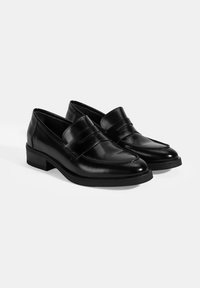 Schwarze Leder Mokassins mit gestickten Details, einem erhöhten Vorderriemen und einem niedrigen Blockabsatz. Glatte Textur und elegantes Design.