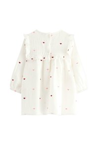 Weißes Langarmkleid mit Rüscheneinsatz, ausgestattet mit einem Knopfverschluss und verstreutem Muster kleiner roter und rosa Herzen. Weicher, strukturierter Stoff.