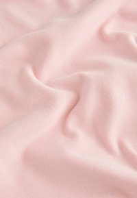 Šviesiai rožinė medžiaga su švelniu, glotniu paviršiumi ir subtiliu blizgesiu, turinti lengvus raukšles ir klostes visame paviršiuje.