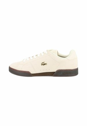 Sneaker basse color avorio con lacci bianchi, suola marrone e piccolo logo coccodrillo sul lato.