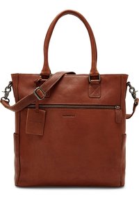 Sac fourre-tout en cuir marron avec deux poignées, bandoulière réglable, poche avant zippée et une petite étiquette attachée. Surface texturée.