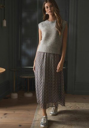 Harmaa ilmanhiha sweater, jossa on ribbaushelma, yhdistettynä pastelli sävyiseen, laskostettuun maxi-hameeseen ja hopeisiin metallin värisiin lenkkareihin.