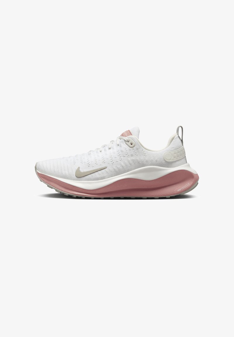 Weiße Sportschuhe mit strukturierter Oberseite, pinkfarbener Zwischensohle, grauen Akzenten und Nike-Logo. Sie verfügen über eine gepolsterte Sohle und ein Schnürsystem.