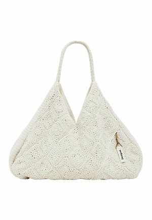 Bolso tote grande de crochet beige con un solo asa y una pequeña etiqueta blanca con la palabra "Desigual", sujeta con un clip dorado.