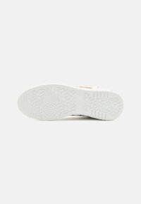 Weiße Sneaker-Sohle mit einer strukturierten GummOberfläche und gemusterten Rillen für Traktion, Größe 42, mit glatten Kanten.