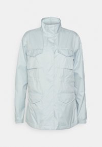 Ljusblå, långärmad jacka med hög krage och fyra framfickor med lock, elastiska ärmslut och framknäppning täckt av en flik.