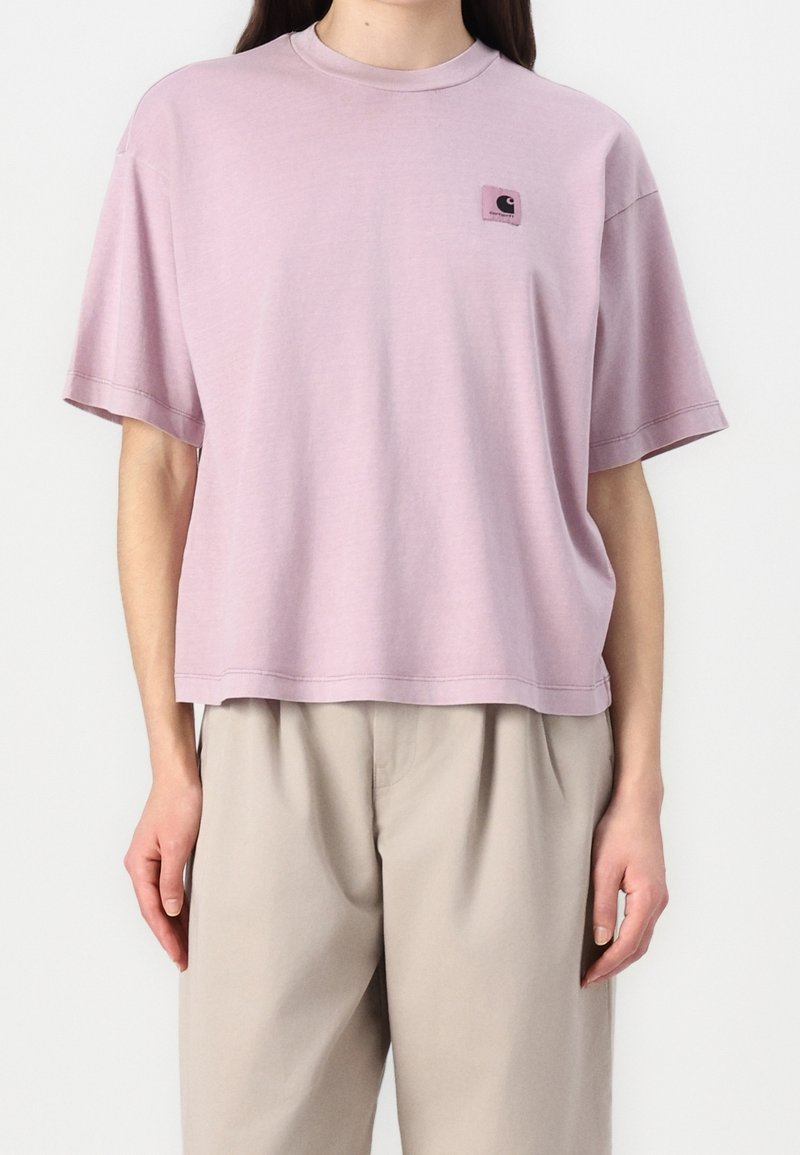Light pink short-sleeve T-shirt with a round neckline and a square patch logo on the left chest. Soft fabric with a relaxed fit.