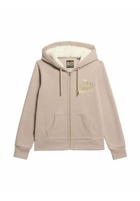 Beige ritshoodie met een zachte witte voering, grote voorzakken en een gouden geborduurd logo op de borst. Voorzien van koordjes op de capuchon.