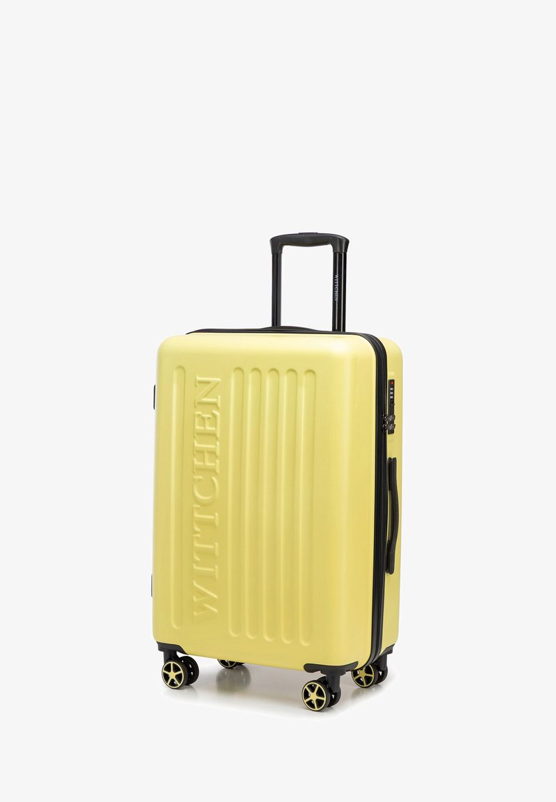 Tvrdý žlutý kufr s vertikálním žebrováním, černými zipy a úchyty a čtyřmi kolečky s víc směrovým pohybem pro snadnou manipulaci.