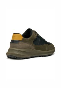 Sneaker vert olive avec des accents en cuir noir, en matériau suédé, semelle en caoutchouc texturé et détail de talon orange. Dispose de lacets et d'un design ventilé.