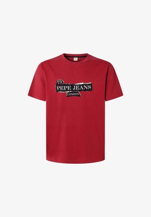 Raudonas medvilninis marškinėlis su juodai baltu logotipu „PEPE JEANS LONDON“ ir skaičiumi „73“, vaizduojančiu suplėšyto popieriaus dizainą. Trumpomis rankovėmis ir apvalia apykakle.