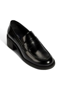 Zwarte lakleren loafers met een blokhak, voorzien van decoratieve stiksels en een klassieke pennystrap detail over de voorkant.