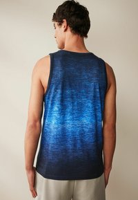 Sinine gradientiga tank top, millel on tekstureeritud kangas, mis üleminek tumedast nirest helesiniseni, kujundatud ümmarguse kaelusega ja ilma varrukateta.