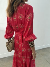 Czerwona sukienka w serca i oczy, z bufkami i wiązaniem w talii. Udekorowana rękawem w panterkę i brązową torebką kopertówką.
