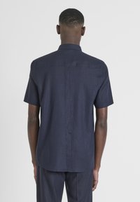 Korte mouwen marineblauw shirt gemaakt van een gestructureerde stof, met een achternaad en een opstaande kraag, in een reguliere pasvorm.