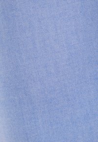 Gros plan d’un tissu bleu clair avec un motif tissé quadrillé fin et serré.