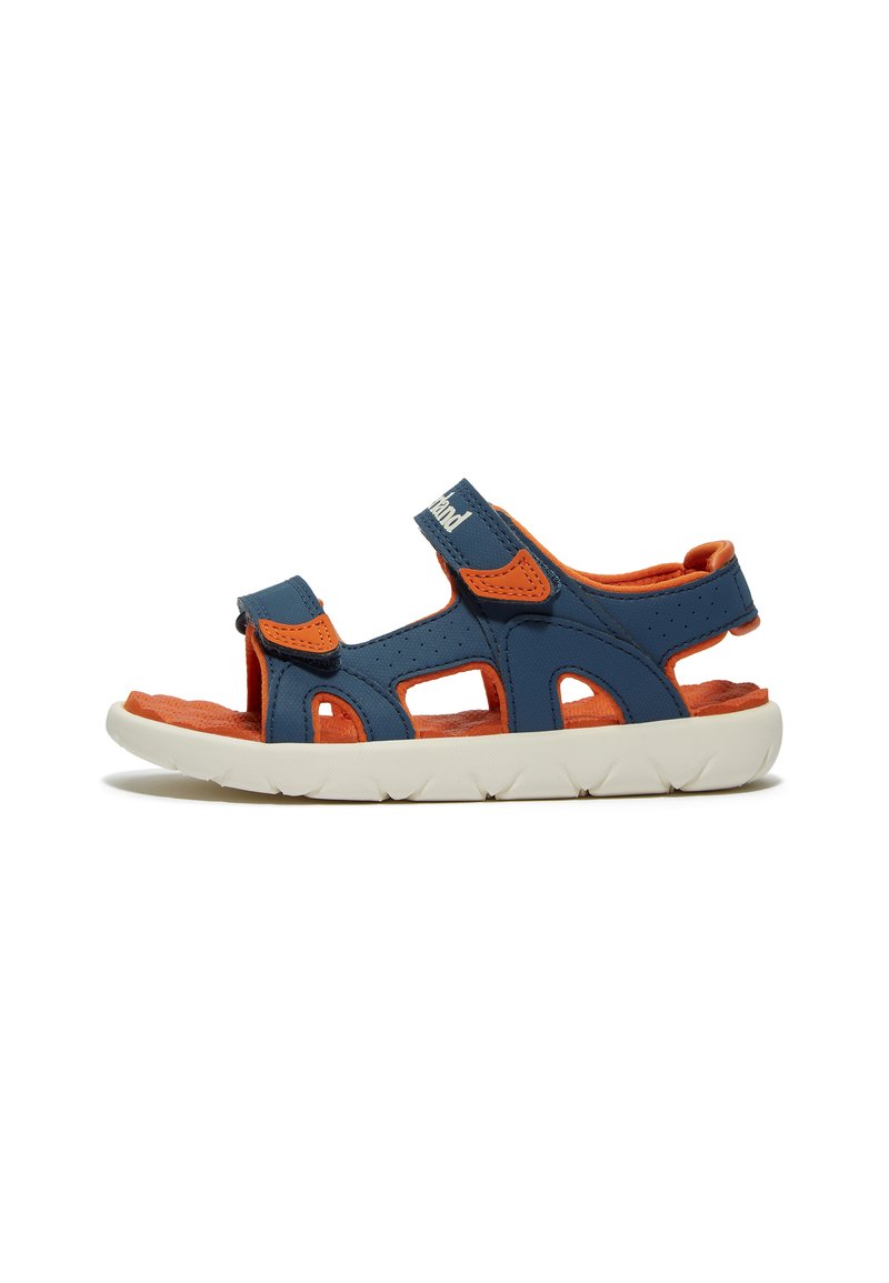 Blaue und orange Sandale mit geschlossenem Fersenteil, offenem Zehenbereich, Klettverschlüssen, ausgeschnittenen Designs und einer weißen Gummisohle mit strukturierten Rillen.