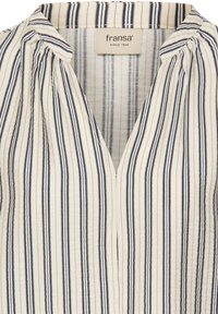 Blouse blanche à rayures verticales bleu marine, col en V et épaules froncées. Confectionnée en tissu texturé avec une sensation légère.