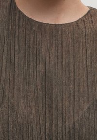 Ruske pleated-kangasta, jossa on hieno kiilto, ohuita pystysuoria viivoja ja pyöristetty pääntie, luoden tekstuurisen pinnan.